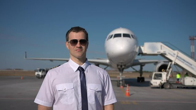 Airport, pilot airplane. Portrait of confident male pilot in uniform keeping arms crossed in background plane aircraft, Travel professional captain travelling transportation professions people concept