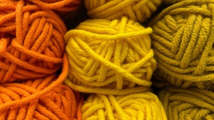 Yellow and orange range of wool yarn. Multicolored skeins of wool close-up