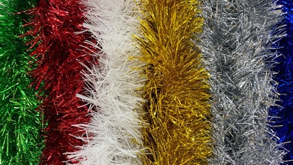 Multicolored tinsels. Christmas decorations close-up, abstract background or texture, beautiful and shiny toys. New Year's tinsel. Christmas and New Year