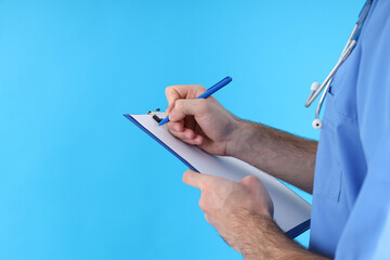 Male nurse with clipboard on blue background