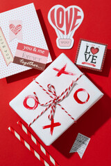 Valentine's Day accessories on red background, top view