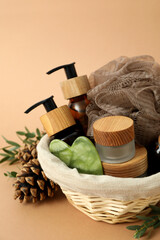 Fototapeta na wymiar Concept of gift with basket of cosmetics on beige background