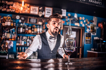 Barman mixes a cocktail on the bar