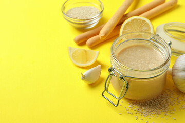 Concept of tasty food with tahini sauce on yellow background