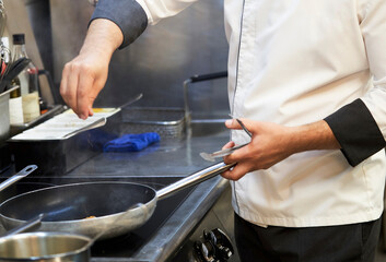 Chef cooking food in restaurant kitchen, close-up
