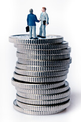 businessmen figurine on top of a stack of coins