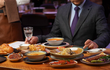 Obraz na płótnie Canvas Man with menu in a restaurant taking order at table