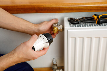 Repair heating radiator close-up. man repairing radiator with wrench.