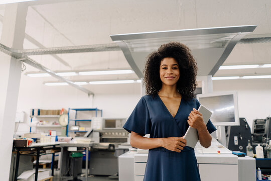 Mid adult businesswoman with digital tablet standing in industry