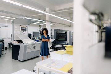 Businesswoman with arms crossed standing in printing industry