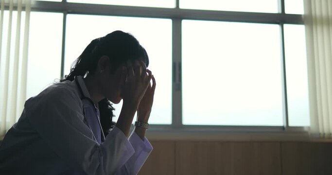 A depressed young woman sit in a chair, stressed and anxious. She sat in the hospital alone, worried about her health.