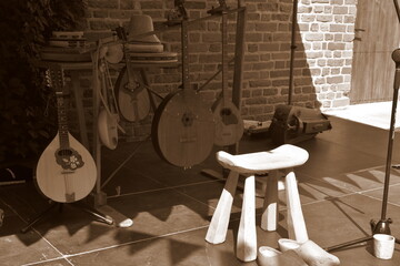 A sepia photo of a set of musical instruments used to play medieval music, including banjo, guitar,...