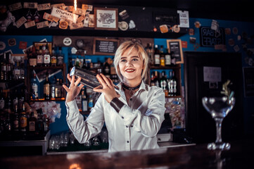 Girl barman creates a cocktail on the taproom