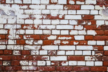 The wall is made of red and white old, ancient bricks. The texture of the background for the design of advertising or graffiti.