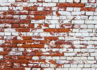The wall is made of red and white old, ancient bricks. The texture of the background for the design of advertising or graffiti.