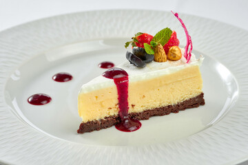 Cheesecake with sauce in a white plate on a white plate