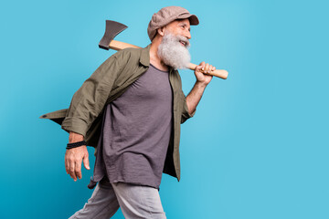 Profile photo of funny old man wearing khaki shirt cap do with wooden axe isolated over vivid blue color background