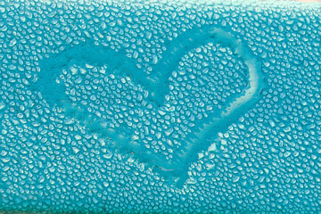 A heart shape drawn on water droplet  blue background