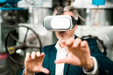 Businessman gesturing while using virtual reality headset at workshop