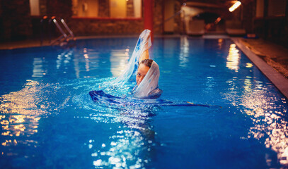 Pretty young woman relaxing in the pool.