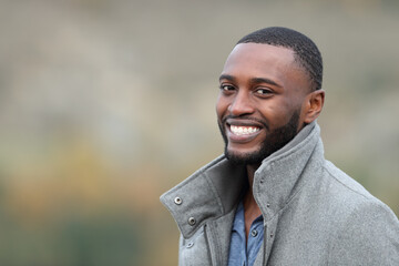 Happy man with black skin looking at you in winter