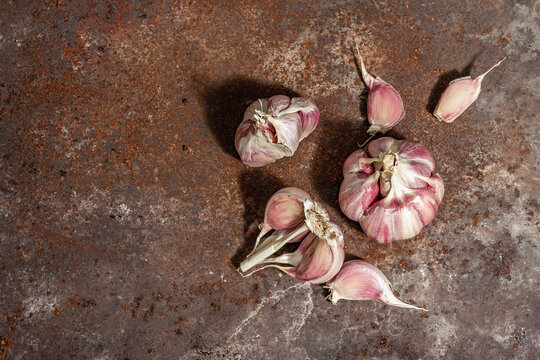 Fresh ripe garlic cloves on a rusty metal background, close up