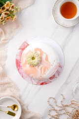 Trendy mousse cake with mirror glaze decorated. Modern european desserts at white marmer stone background.