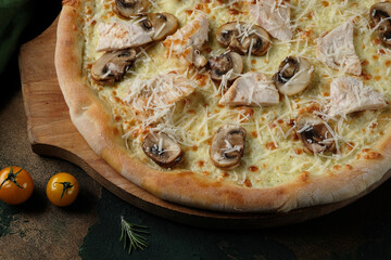 Pizza with mushrooms and chicken on a green wooden background