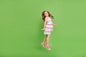 Full length body size photo small girl jumping up cheerful careless overjoyed isolated pastel green...