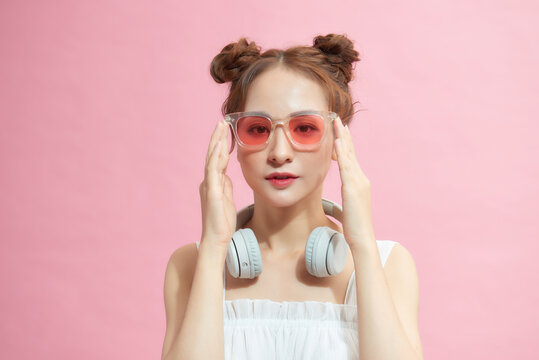 Photo of young woman happy positive smile hand touch sunglass cool isolated over pink color background