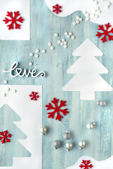 Minimal Christmas panoramic background. Silver baubles, christmas tree, red soft felt snowflakes. Light green textured board, abstract organic shapes. Backdrop for stories about winter holidays.
