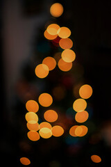 Defocused christmas tree with bokeh lights, indoor photography, close up, christmas spirits