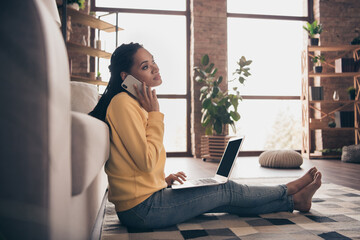 Photo of sweet shiny young woman dressed yellow sweater sitting floor talking modern device indoors home room