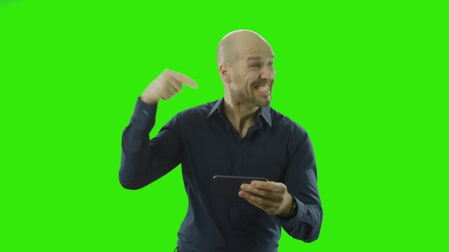 man cheering and pointing at his phone in front of a greenscreen