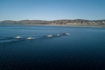 Obraz premium Amphibious offroad vehicles crossing the Lena river 