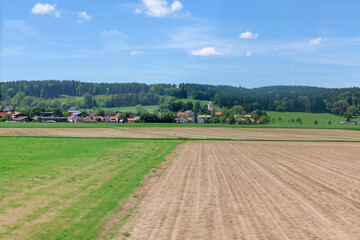 Village and agricultural field in Germany . Rustic springtime scenery . Plowing land in the spring 