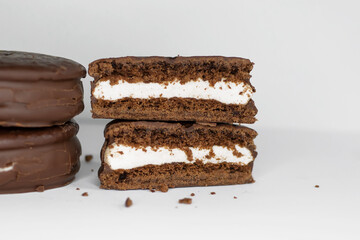 Cookies in chocolate glaze and cream filling on a white background.