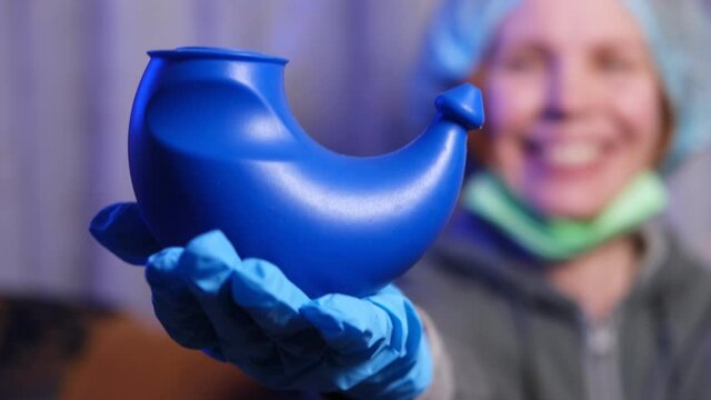 A device for washing the nose - neti pot in the hands of a woman doctor.