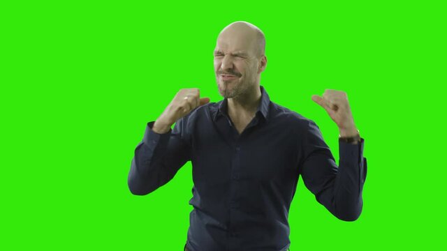 successful man is cheering at the camera and give thumbs up in front of a greenscreen