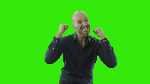 successful man is cheering at the camera in front of a greenscreen
