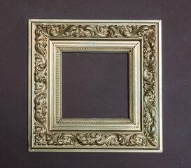 Photo of golden frames for paintings and photos on a purple wall. Interior and abstraction