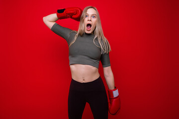 Sporty young woman in red boxing gloves having fun