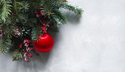 Christmas wallpaper, made of fir branches, red baloon, red berries and cons on grey background. Christmas wallpaper.