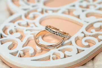 two wedding rings on a carved wooden stand