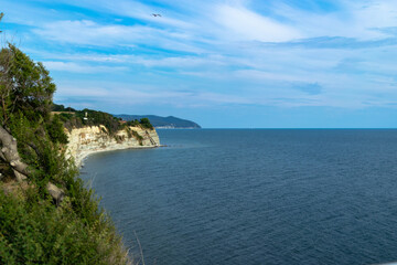 Steep coastline by the sea and blue sky.