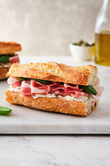 Ciabatta Sandwich with Jamon Serrano and spinach, on white background.
