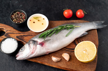 raw sea bass fish with spices on a stone background