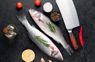 raw sea bass fish with spices on a stone background