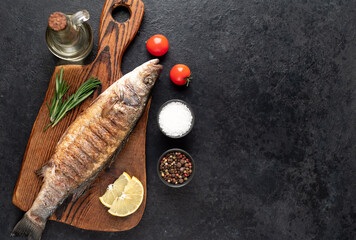 grilled sea bass fish on a stone background with copy space for your text
