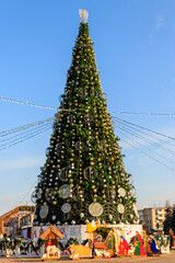 Decorated Christmas tree and Christmas Nativity scene in a city park
